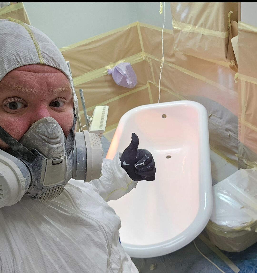 photo of glossy baths owner photo of glossy baths re-enamelling owner Seamus with a thumbs up, in ppe, in a room full of masking up and a completed bath in Cardiff